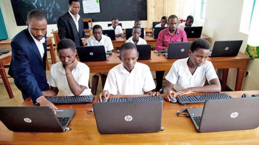 An instructor helps a student during a computer class. / File photo