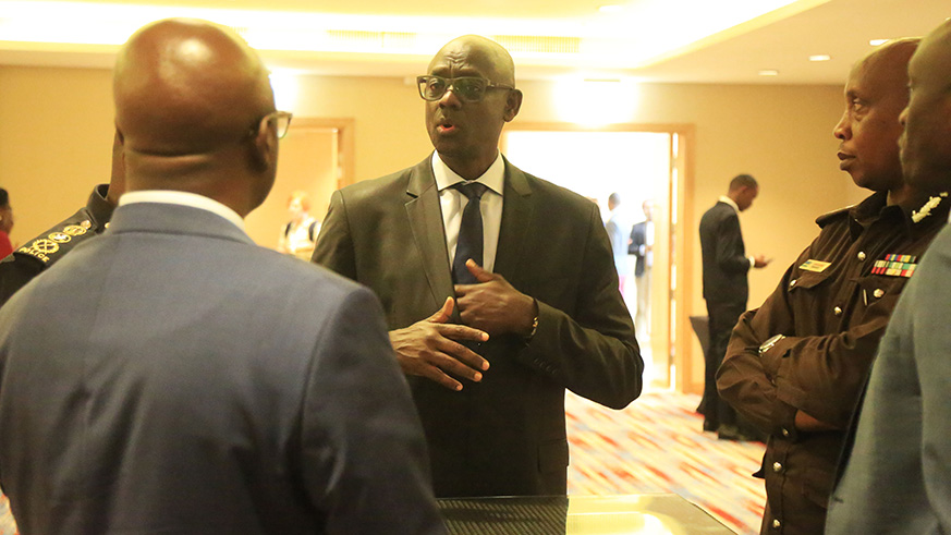 Minister Busingye chats with officials after the opening of RIBu2019s consultative workshop on services delivery for fair justice in Rwanda on Thursday. Sam Ngendahimana.