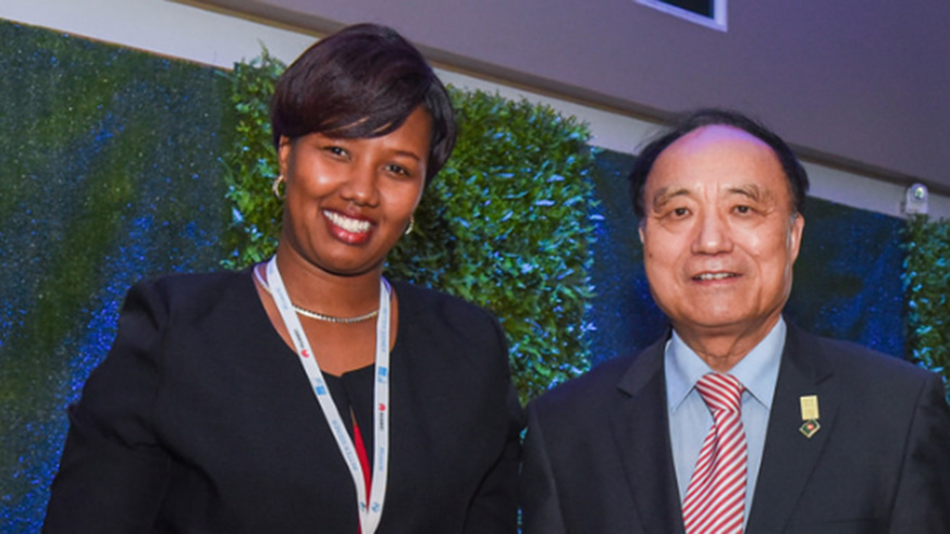 The Managing Director of CHARIS UAS, Ingabire Muziga Mamy (L) receives the International Telecommunications award from ITU Secretary General Houlin Zhao. Courtesy.
