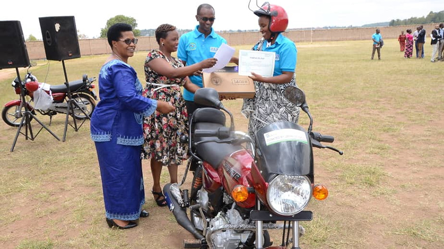 Restituta Mutuyimana receives a motorcycle and certificate as the best teacher in Southern Province. Michel Nkurunziza.