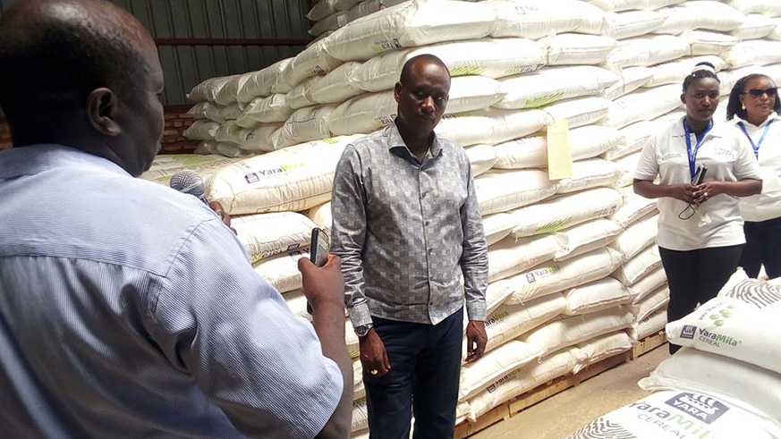 Owners of the storage facility speak to  Kayonza Mayor Murenzi (centre) about the new fertilisers they received.
