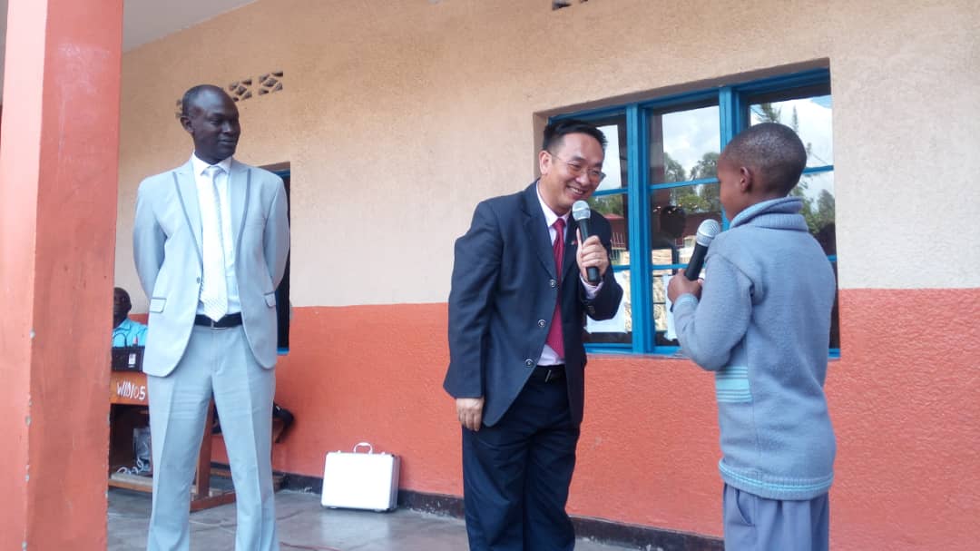 The Confucius Institute director in Rwanda, Zhang Xian salutes in Chinese Language with a primary two pupil from Wisdom Schools in Musanze District. Regis Umurengezi