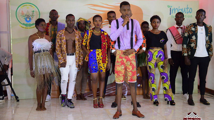 A budding fashion designer (in front) showcases his collection to the judges. 