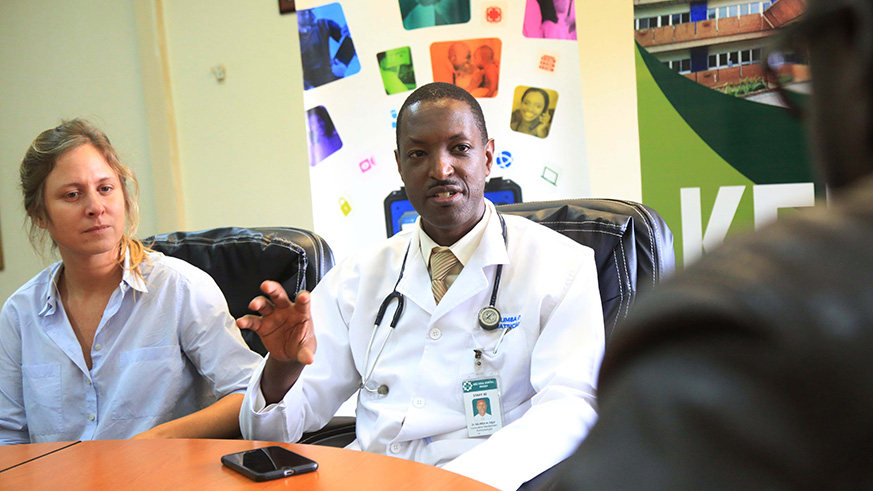 Dr Edgar Kalimba, Consultant Pediatric Pulmonologist and Director Mother and Child division at Oshen-King Faisal Hospital, gestures during the interview as Andrea Malet, the hospital Corporate Social Responsibility Manager, looks on in Kigali yesterday. Sam Ngendahimana.