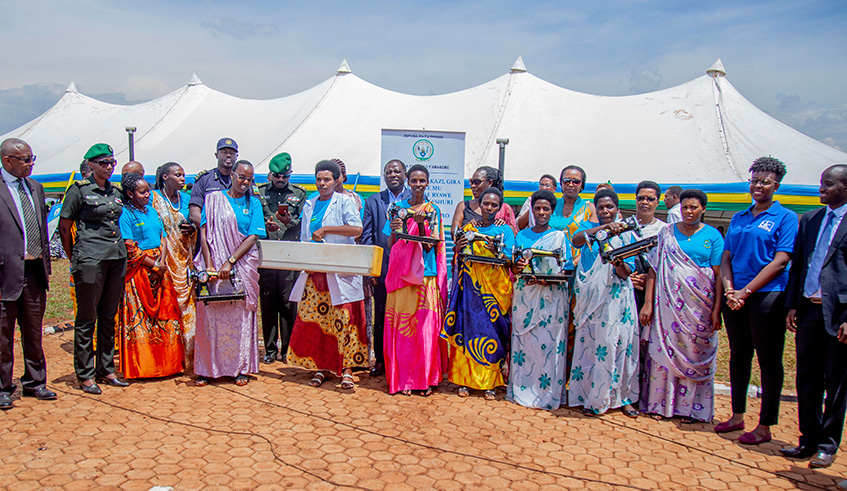 Officials pose for a group photo with rural women after handing to them tool kits to improve their lives. Photos by Jean du2019Amour Mbonyinshuti.