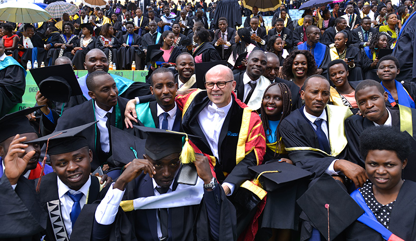 Jubilant University of Rwanda graduates with the Universityu2019s Vice Chancellor, Prof. Philip Cotton, at the graduation ceremony at Huye Stadium yesterday. Some 6,540 graduated with bacheloru2019s degrees and 510 with masteru2019s degrees while one received PhD. Courtesy.
