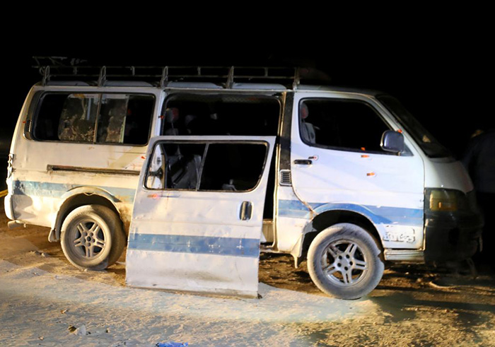 Policemen stand beside the microbus which carried Coptic Christians when gunmen opened fire in Menyia, on Friday. Net photo.