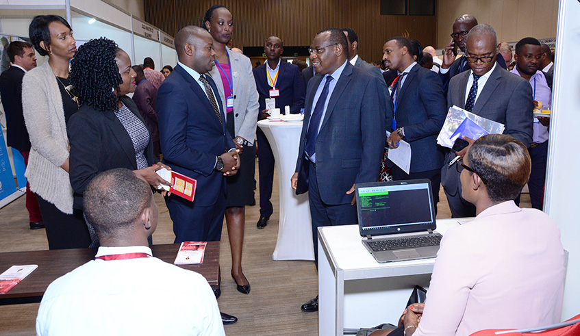 Minister Gatete interacts with Sonarwa officials in exhibition hall during four-day Renewable Energy for Sustainable Growth Forum. The officials from the firm say some clean companies have picked interest in getting ensured. (Emmanuel Kwizera)