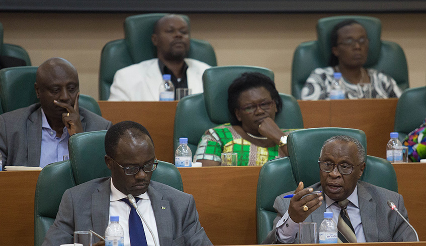 Bishop (Rtd) John Rucyahana (R) presents the commissionu2019s report to the senate yesterday. Looking on left is NURC executive secretary Fidel Ndayisaba. Nadege Imbabazi