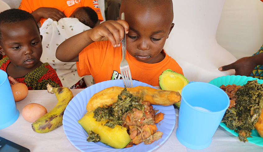 Cchildren feed on orange fleshed sweet potato during the CIP field visit in Musanze. 