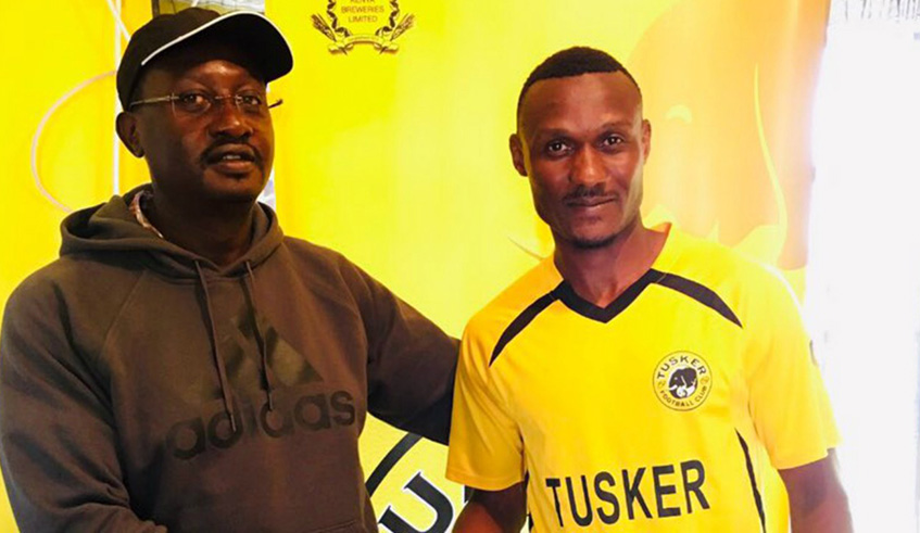 Amini Muzerwa (right) with a Tusker FC official after inking his two-year deal on Tuesday. Courtesy.
