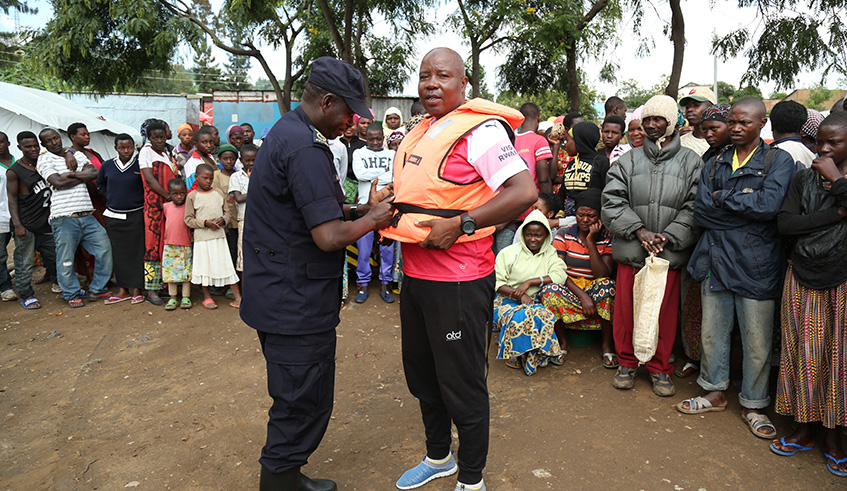 ACP Elias Mwesigye, Commanding Officer, Marine Unit, demonstrate to fishermen and residents how to wear a life jacket. Courtesy.