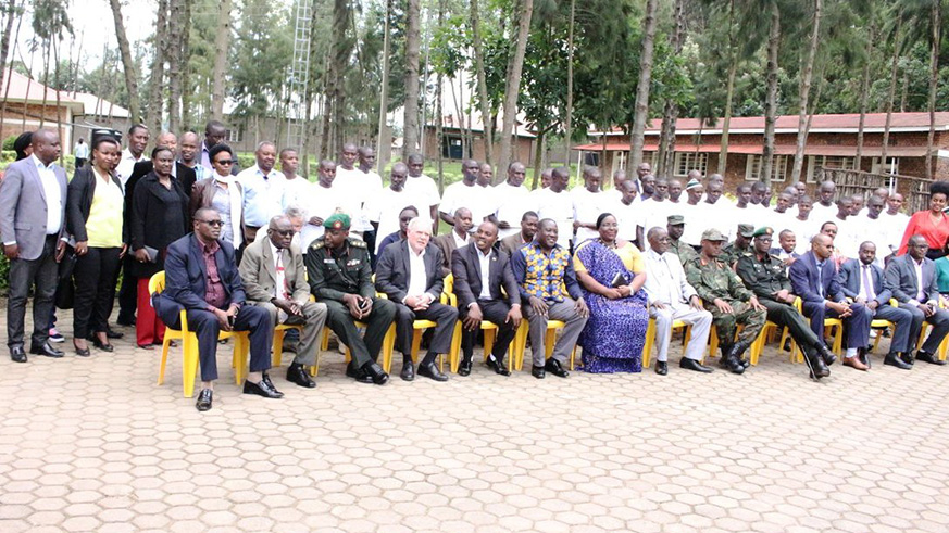 Officials pose for a group photo with former members from various armed groups at Mutobo Demobilisation Centre. Regis Umurengezi