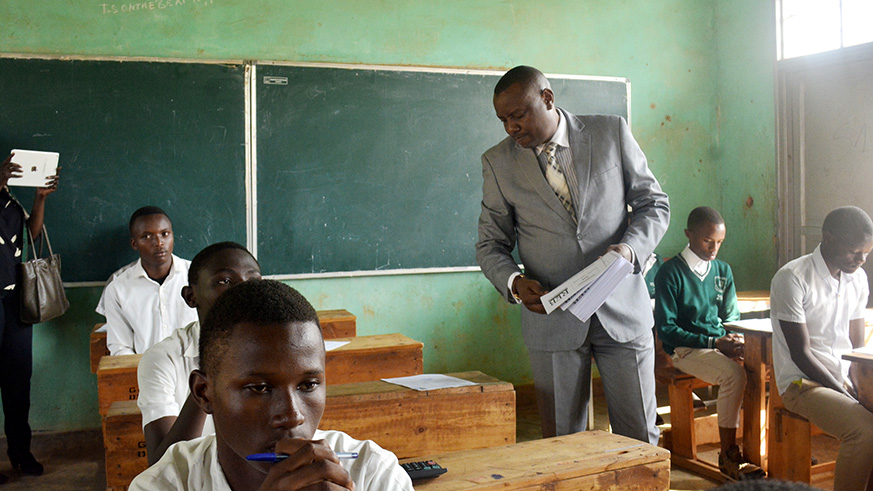 The State Minister Isaac Munyakazi distributes papers of the exam. / Frederic Byumvuhore