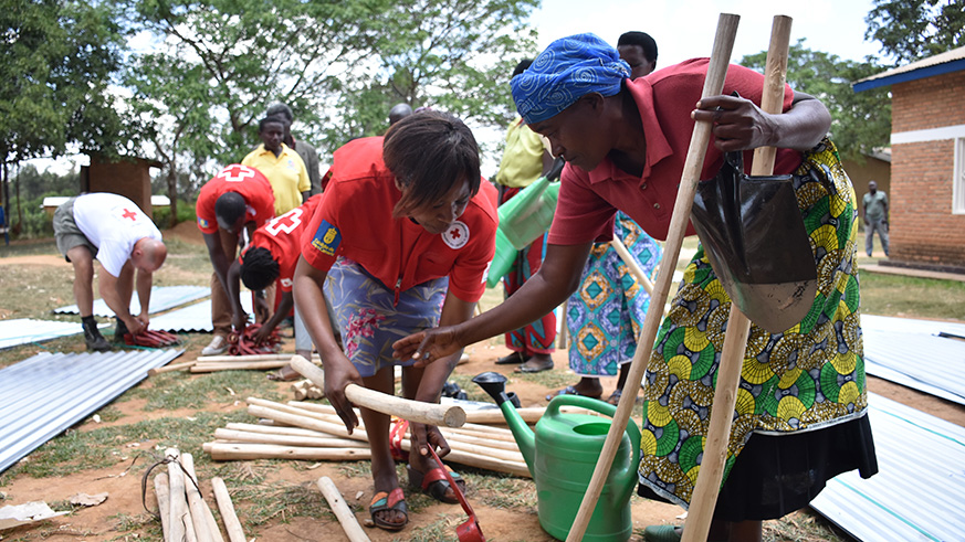 Speciose Nyiranteziryayo (R) receives some donations from a Red Cross volunteer. / Courtesy