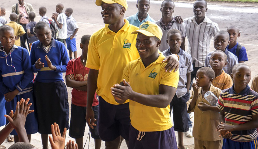 Tharcisse Kamanda (smiling on the left) has been part of the rugby federationu2019s leadership since 2012. He is seen here in a past outreach programme to introduce the sport to rural primary schools. Net photo.