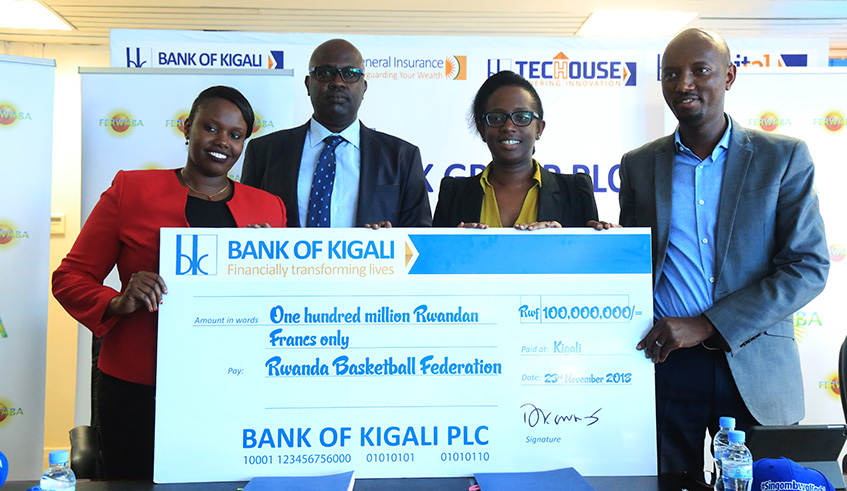 Ferwaba president Desire Mugwiza (2nd-left) receives the Rwf100 million dummy cheque from Bank of Kigali Chief Executive Dr Diane Karusisi (2nd-right) on Friday. Sam Ngendahimana.