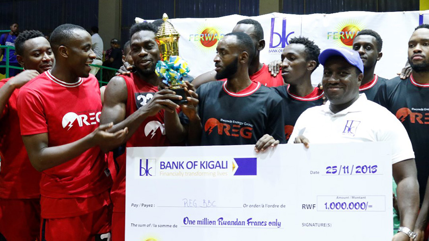 REG basketball team players celebrate with the trophy and their Rwf1m dummy cheque after beating Espoir 80-63 to reclaim the title at Amahoro Stadium on Sunday. Courtesy.