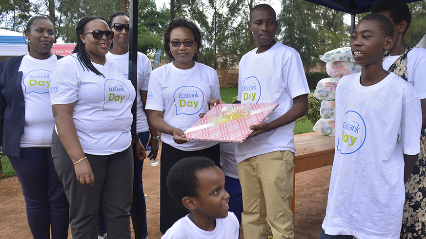 Alice Kilonzo Zulu, (Centre) the managing director of the Ecobank in Rwanda recieves a gift from Brothers of Charity HVP Gatagara.