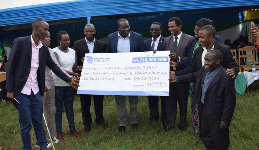 The Governor of Northern Province, Jean Marie Vianney Gatabazi (5th left) hands over the Rwf 61,750,000 dummy cheque to the committe of persons with disabilities in Gakenke District. Ru00e9gis Umurengezi.