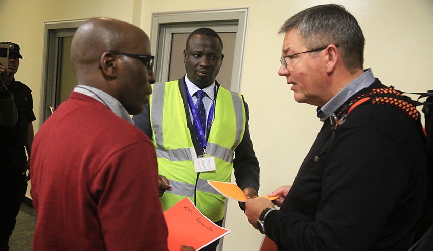 A Danish official (right) speaks to Genocide suspect Wenceslas Twagirayezu as John Bosco Siboyintore, the head of the Genocide Fugitives Tracking Unit, looks on upon Twagirayezuu2019s arrival at Kigali International Airport on Tuesday. Sam Ngendahimana.