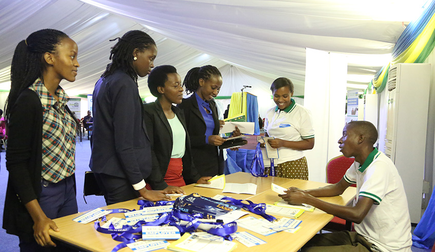 Job seekers get some information during an open day where they meet with job providers at Kigali Conference and Exhibition Village. Sam Ngendahimana.