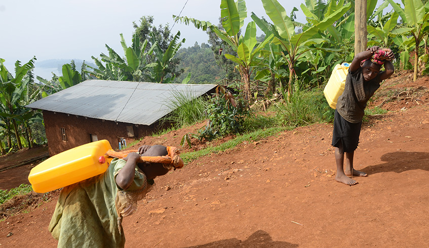 Two young girls carry jerry cans of water in Nkombo Sector, Rusizi District. The Goverment has taken measures to raise community awareness about child labour. Sam Ngendahimana.