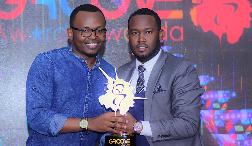Celeb Uwagaba (right) hands an award to a winner. photo by Frederic Byumvuhore