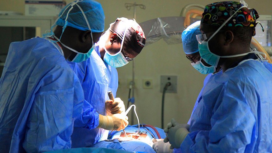 Prof Alexis Butera (centre) leads other doctors while operating a patient at King Faisal Hospital. Sam Ngendahimana.