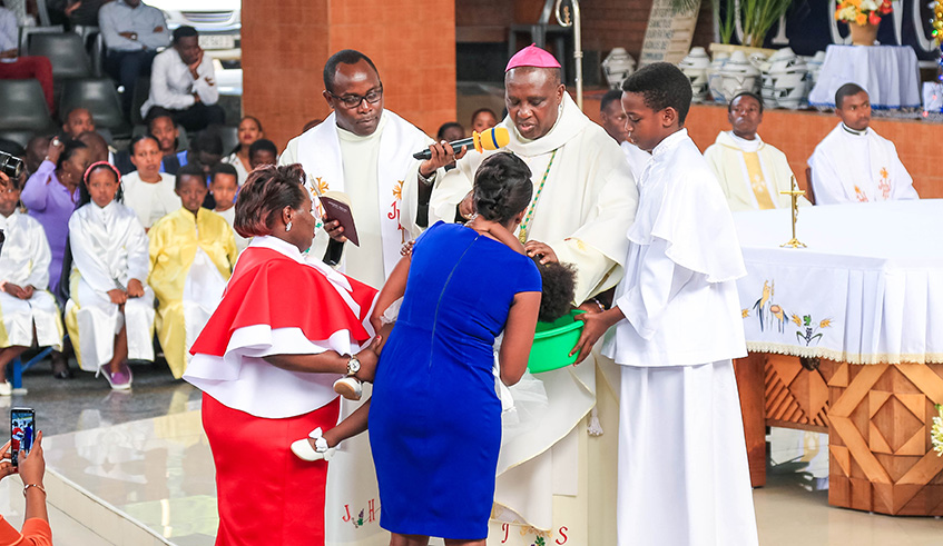 The new Archbishop of Kigali Diocese Antoine Kambanda baptises a child at Saint Michel Cathedral in Kigali on Christmas Day. Emmanuel Kwizera.