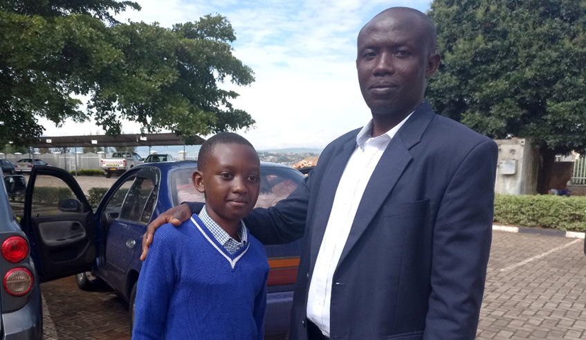 Yves Hakizimana, 11, with his father Pascal Hakizimana in Kigali yesterday.