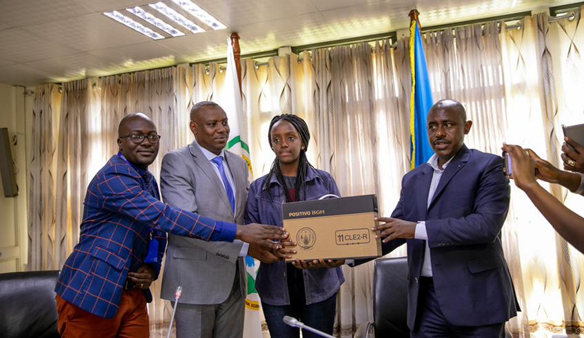 Ishema Blessing Gianna, the best performer in the 2018 PLE recieves a gift from officials of the ministry of education. File
