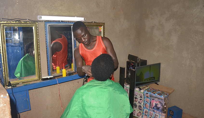 Access to electricity has helped Viateur Sindambiwe to start a barber saloon.Frederic Byumvuhore