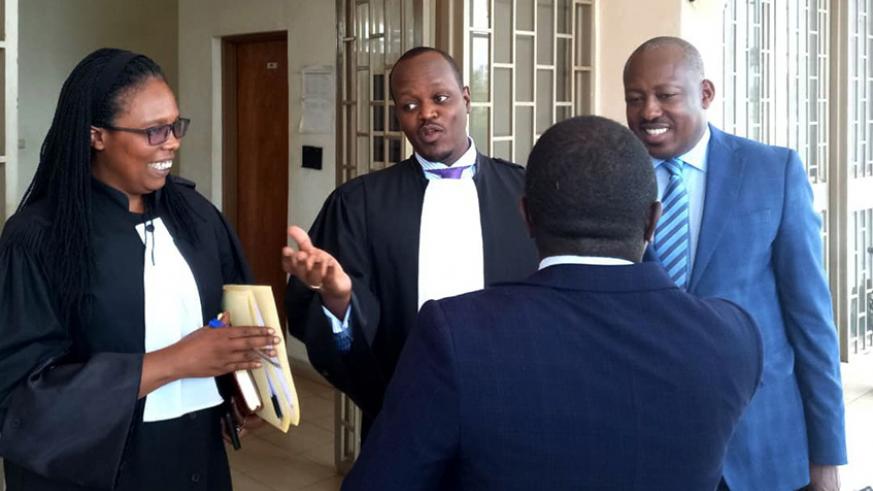 Richard Mugisha (right) chats with his legal team at the Supreme Court yesterday. / Courtesy