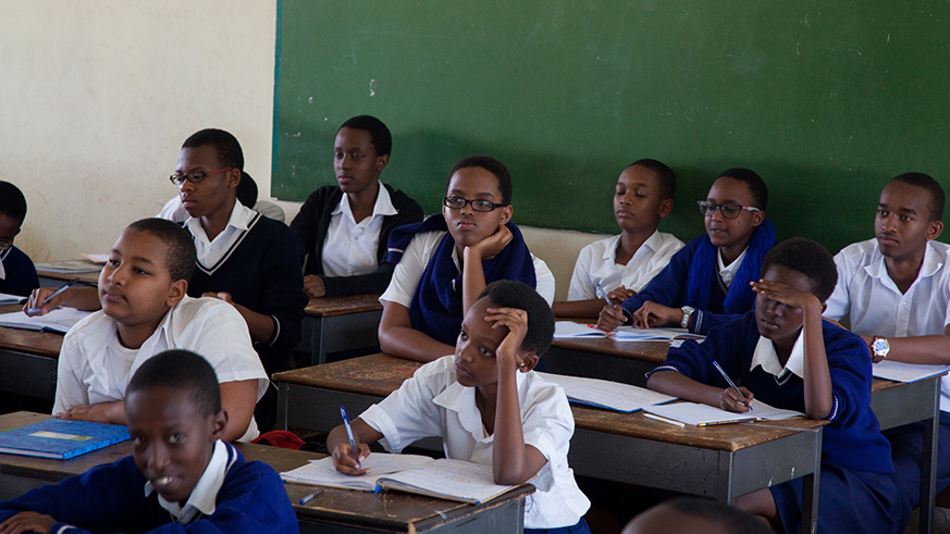 Secondary school students attentively listen to a teacher during a lesson. File.