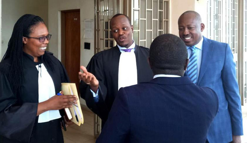 Richard Mugisha (right) engages his legal team . Courtesy.