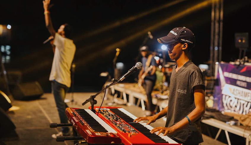 The young and talented music producer (right) performs at a past event in Kigali.  Courtesy .
