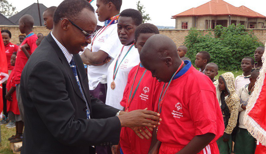 Pastor Deus Sangwa awards medals to best performers during a past Special Olympics event in Muhanga District. File.