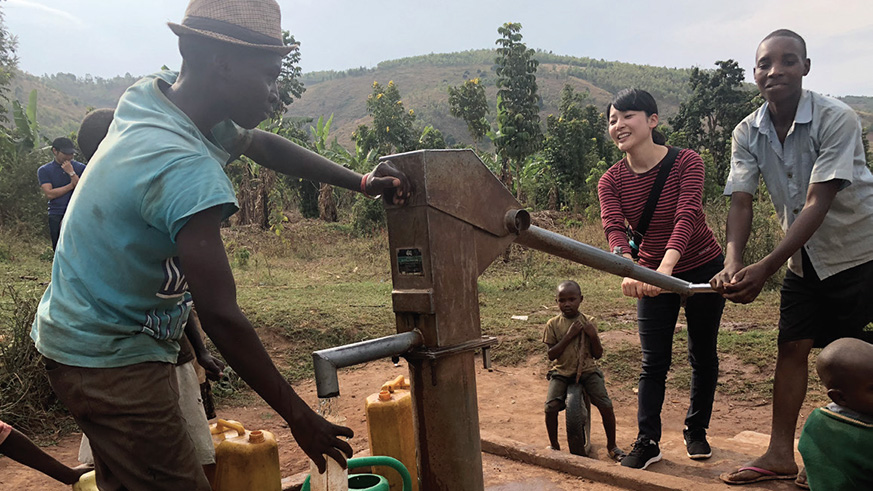 A JICA volunteer and local residents using hand pump that was rehabilitated by by the JICA