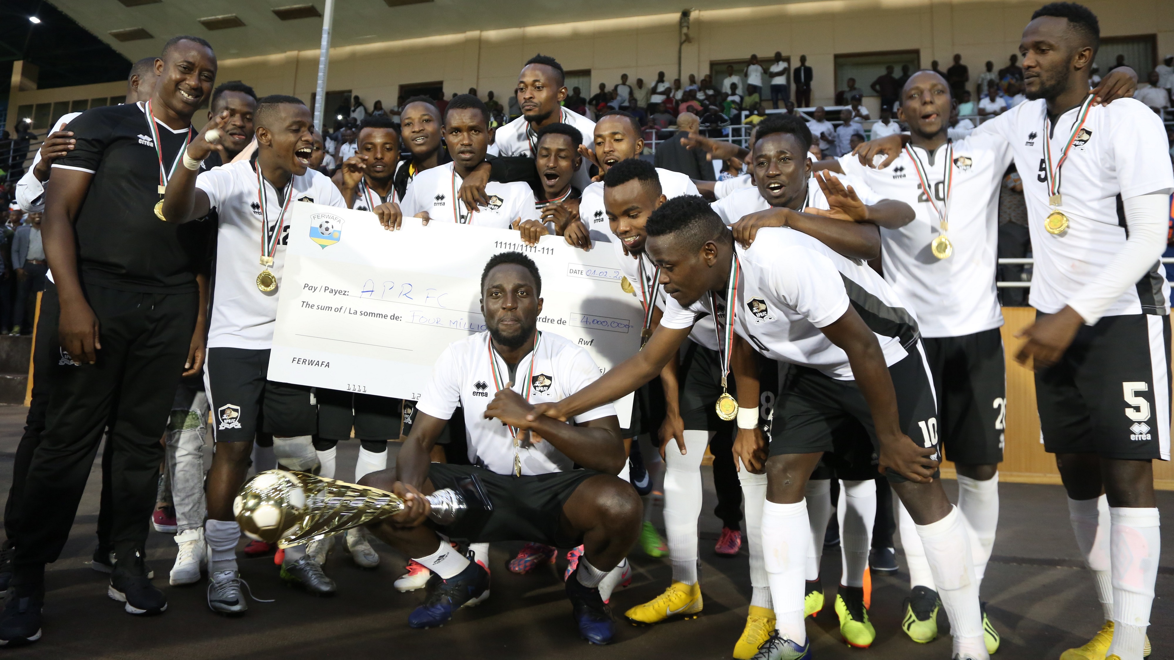 APR players celebrate, with the trophy and Rwf4 million dummy cheque, after beating rivals Rayon Sports 1-0 to win this year's Heroes Cup title at Amahoro National Stadium on Friday. Sam Ngendahimana