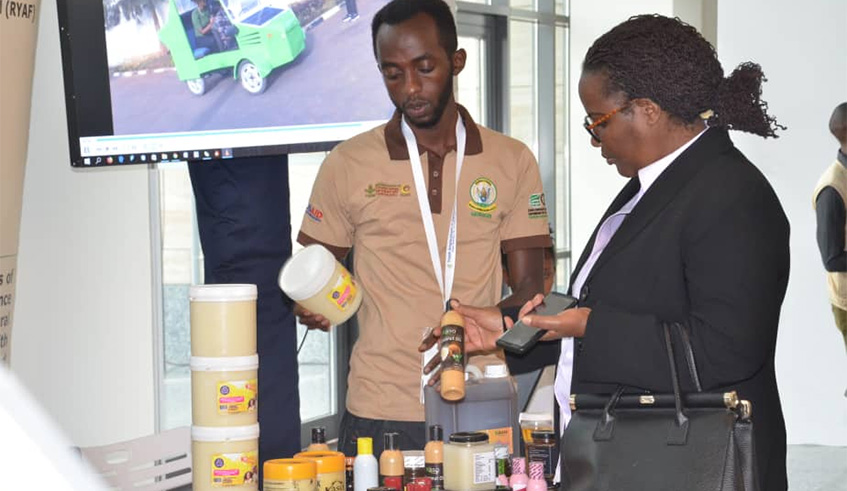 Shafi Hagenimana shows a customer some of his products. Courtesy.
