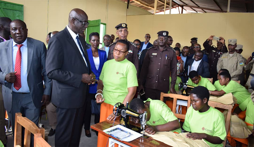 Busingye (2nd left) inspects tailoring activities done by  female inmates in Musanze Prison as other officials look on. Ru00e9gis Umurengezi.