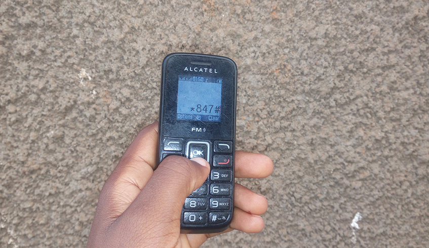 An Irish potato farmer using the application on her simple phone in Musanze District. Ru00e9gis Umurengezi.