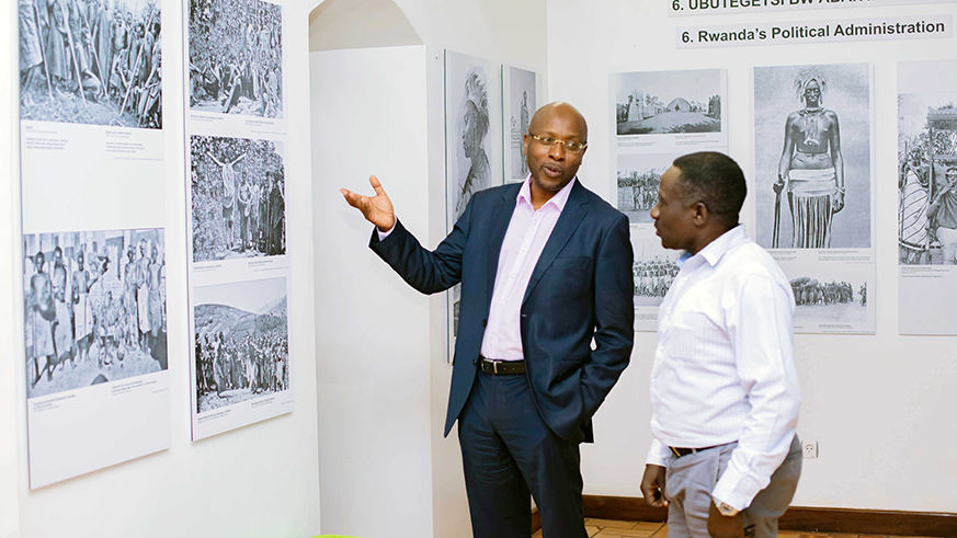 Masozera (L) shows a guest some of the 15 cultural heritage projects at the Kandt House Museum . Emmanuel Kwizera