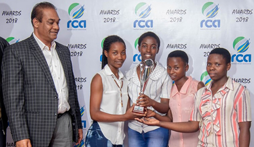 Oscar Kerketta ( left), the High Commissioner of India to Rwanda looks on after presenting an award to female cricketers. Courtesy.