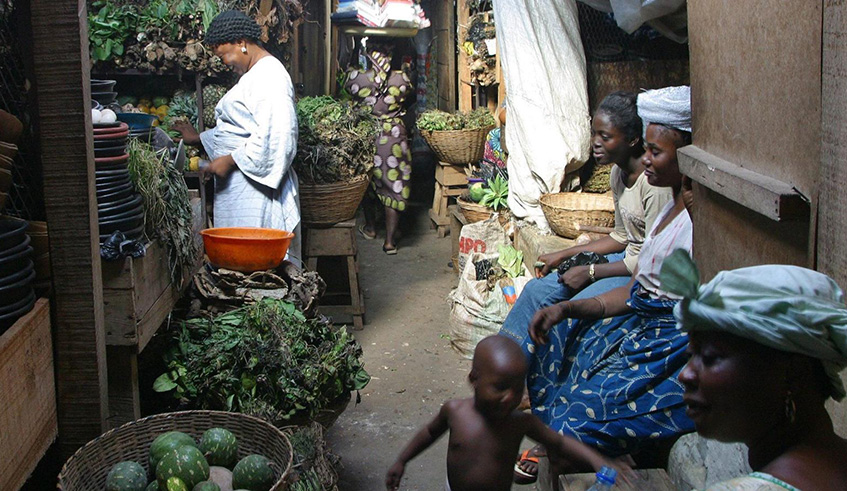 Women selling traditional medicines look at piles of leaves, vines and other herbs for sale at Jankara herbal market in Lagos. Net photo.