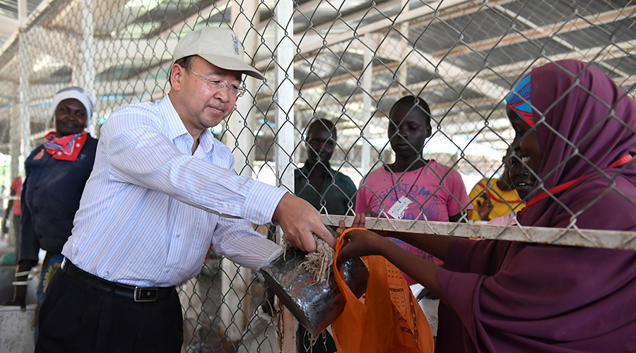 Liu Xianfa (L), then Chinese Ambassador to Kenya, distributes maize donated by the Chinese government to refugees at the Kakuma refugee camp in Kenya, June 7, 2017. / Xinhua/Sun Ruibo