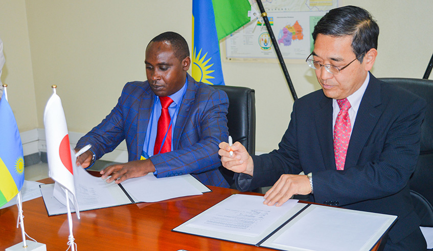 Amb. Takayuki Miyashita and  Murenzi (left) during the signing ceremony. Joseph Mudingu.