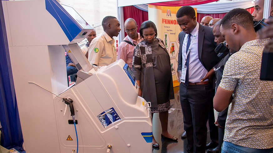 Clare Akamanzi, the chief executive of Rwanda Development Board, with Innocent Lugha Bashungwa, Deputy Minister of Agriculture of Tanzania, and other officials visit a coffee-sorting machine during the African Fine Coffee Conference and Exhibition in Kigali last week. Industry experts believe farmers are still getting far less for their effort compared to other players up the coffee production chain. Emmanuel Kwizera.