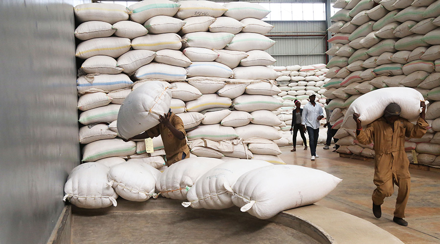Workers in a warehouse in Rwanda trying to fix some coffee packages. / Sam Ngendahimana